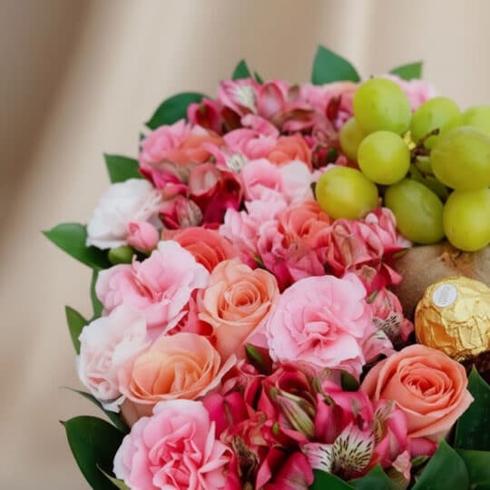 Primer plano de Arreglo AMOS: Caja Corazón de Rosas con Frutas y Ferrero, mostrando rosas rosadas, alstroemerias, uvas verdes